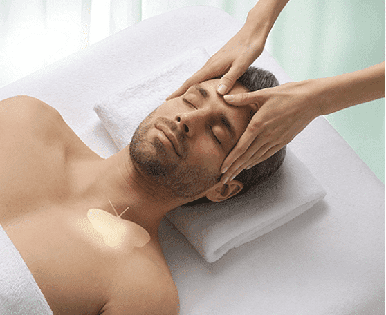 Man receiving relaxing head massage while lying on massage table.