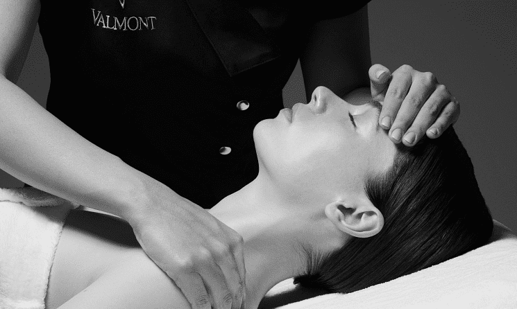Person receiving a relaxing facial and neck massage in a spa setting.